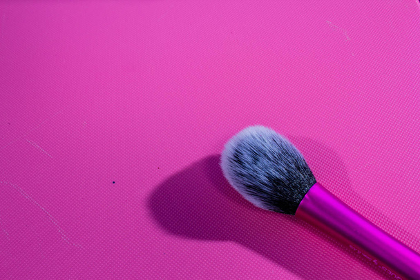 makeup brush on pink background. macro background texture photo for advertising. brush for applying makeup. the brush for mascara - Fotó, kép