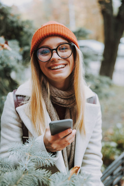 Young girl smiling and holding modern smartphone - Valokuva, kuva
