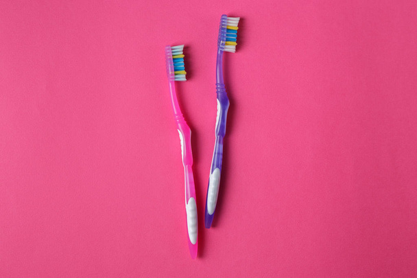 The old toothbrushes on the pink background - Photo, Image