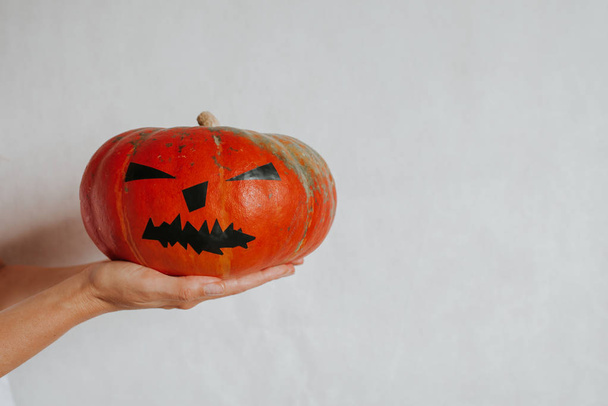 Halloween pumpkin. Woman holding a scary face pumpkin. Happy Halloween party holiday. Celebrate annual in October 31. Autumn season. Fall color, orange and yellow. Trick or treat. Space for text - Foto, imagen