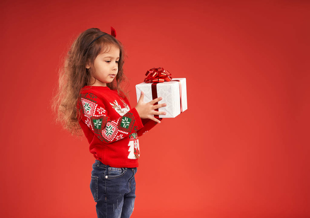 маленькая девочка в окружении новогодних подарков
  - Фото, изображение