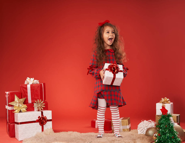 bambina circondata da regali di Capodanno
  - Foto, immagini