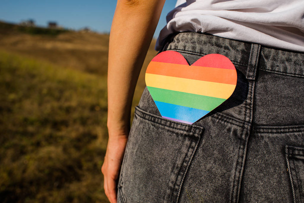 Woman holds in hands a heart in the colors of the rainbow. Young beautiful girl. LGBT history month. Pride Month. Lesbian Gay Bisexual Transgender. LGBT flag. Love, human rights, tolerance. LGBTQ+ - Fotografie, Obrázek