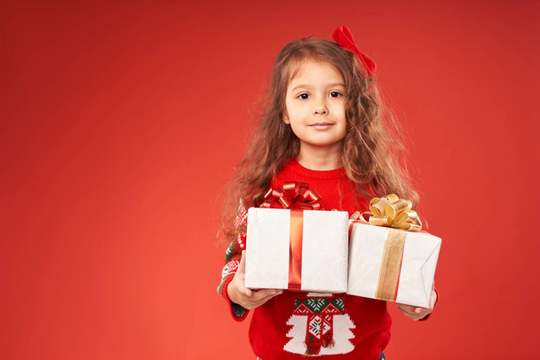 κοριτσάκι που περιβάλλεται από δώρα Πρωτοχρονιάς  - Φωτογραφία, εικόνα
