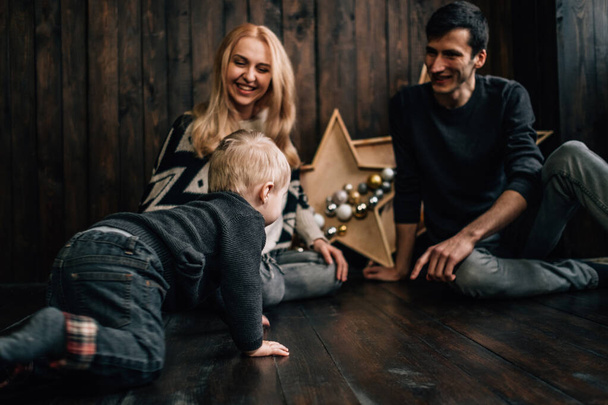 Portrait of Family Mom Dad with One Little Kid Playing in Room Decorated in Christmas Theme - Foto, Bild