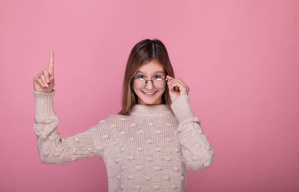Beautiful teenager girl in round glasses shows a finger. - Фото, зображення
