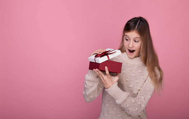 Surprised girl opens a box with a gift. - 写真・画像
