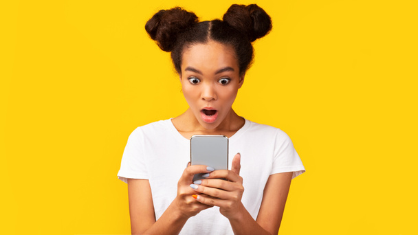 Amazed africano americano ragazza lettura scioccante sms
 - Foto, immagini