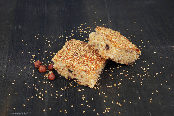 Cake with sesame nuts on black wooden background - Photo, Image