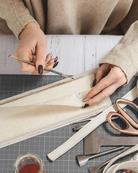 Manos de mujer creando bolso de cuero en un taller
 - Foto, Imagen