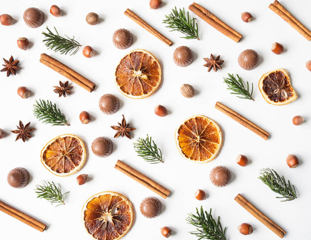 Sweet festive pastry composition with chocolate, dry orange slices, fir tree, nuts and spices on a white background. - Φωτογραφία, εικόνα