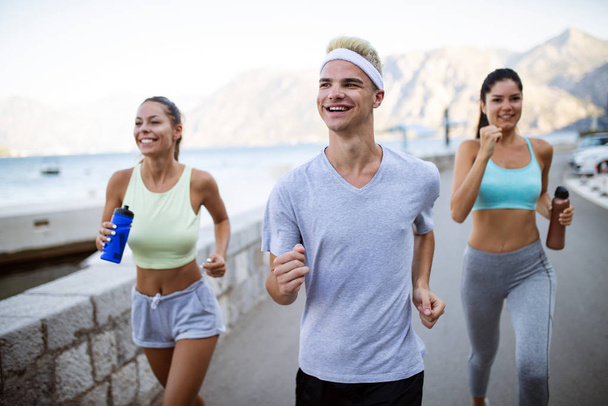 Group of young healthy fit people jogging and running outdoors in nature - Φωτογραφία, εικόνα