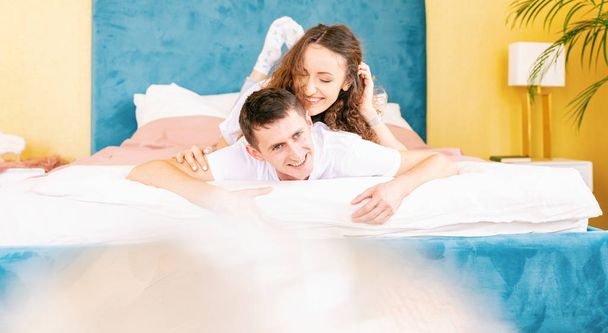 Happy young couple on bed in bedroom have fun, romantic time tog - Φωτογραφία, εικόνα