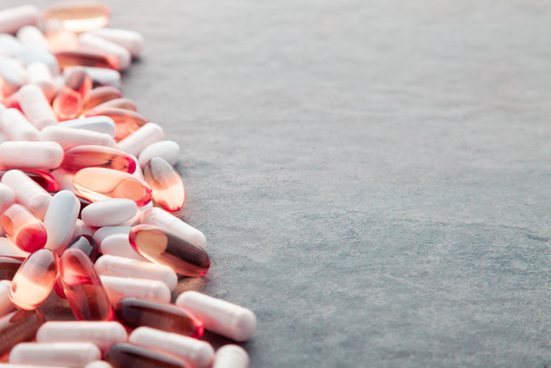 Таблетки, таблетки, капсулы, лекарства, выливающиеся из белой бутылки на W
 - Фото, изображение