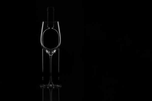 Elegant wine glass and wine bottle on black background. Bottle b - Fotoğraf, Görsel