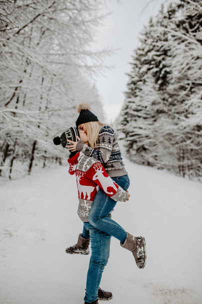 happy couple enjoying in the snowy winter forest . Christmas mood.   - Zdjęcie, obraz