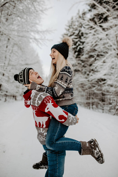 雪に覆われた冬の森で幸せなカップル。クリスマス気分.   - 写真・画像