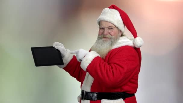 Santa in eyeglasses showing pc tablet. - Кадры, видео