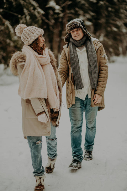 jong paar in liefde poseren in de winter bos  - Foto, afbeelding