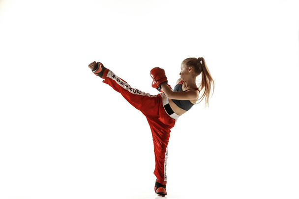 Young female kickboxing fighter training isolated on white background - Photo, image