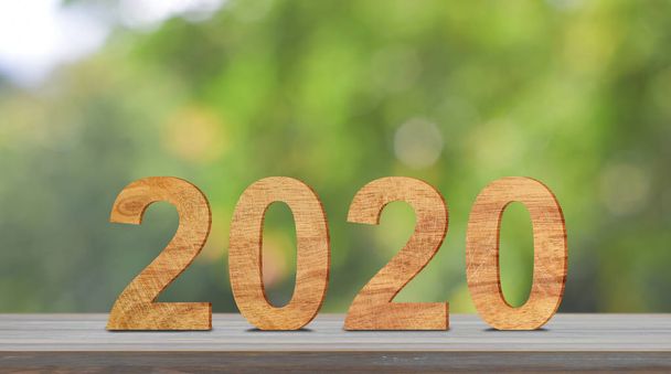 Felice anno nuovo 2020 numero di legno su tavolo in legno con luce solare e sfondo verde bokeh
. - Foto, immagini