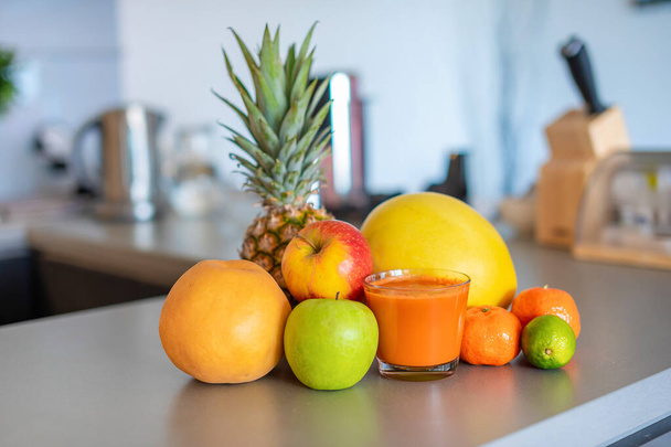 Diferentes frutas tropicales y batidos en el fondo de la cocina del hogar, concepto de estilo de vida saludable
 - Foto, imagen