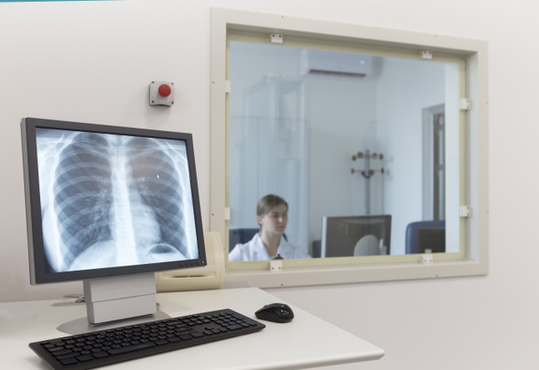 Kadın doktor modern laboratuvarda insan göğsünün röntgenini çekiyor. - Fotoğraf, Görsel