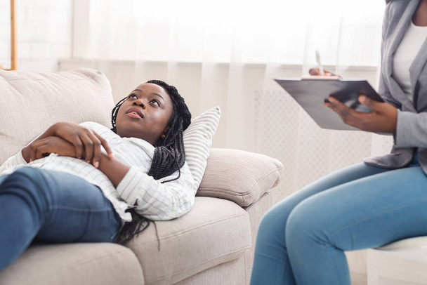 精神療法セッション中にソファに横たわっ落ち込んで若い黒人女性 - 写真・画像