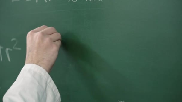 Hand Holding Chalk en het schrijven van een wiskundige formule of vergelijking op het bord. - Video
