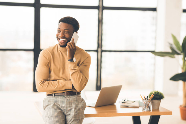 Щасливий чорний бізнесмен розмовляє по телефону
 - Фото, зображення