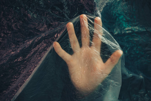 Beautiful abstract plastic cellophane  bag background. Human hand shows palm help stop.  No Plastic Bag Concept, save world, protect earth. - Photo, Image