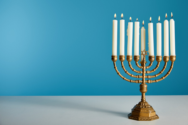 burning candles in menorah isolated on blue - Photo, image