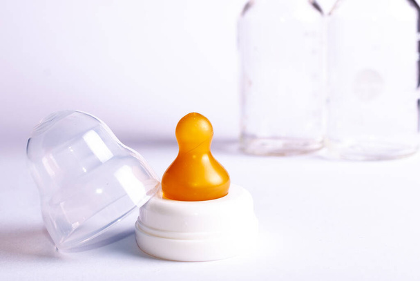 A disassembled baby bottle with natural rubber and glass on white background - Photo, Image