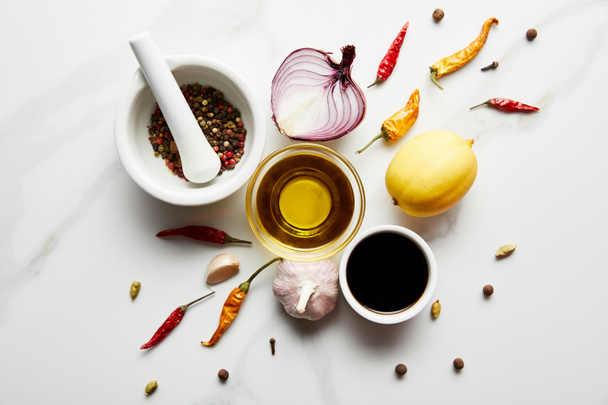 Top view of lemon, olive oil with soy sauce and spices on marble background - Photo, Image