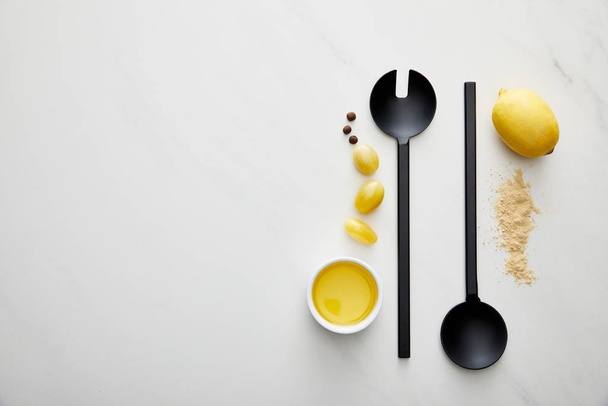 Top view of olive oil with lemon, cherry tomatoes and ladle with spoon on marble background - Fotoğraf, Görsel