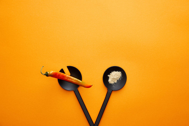 Top view of kitchenware with spice and chili pepper on orange background - Photo, image