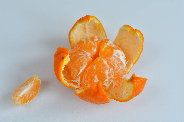kuoritut mandariini valkoisella taustalla.Oranssi hedelmät ja kuoritut segmentti eristetty. Kasa oranssi segmenttien
 - Valokuva, kuva