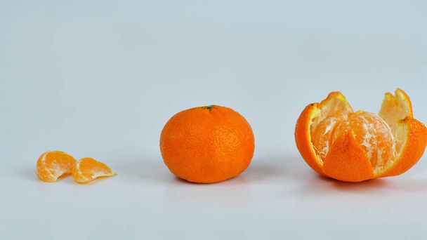 Mandarine auf weißem Hintergrund geschält und Segment isoliert geschält. Haufen orangefarbener Segmente - Foto, Bild