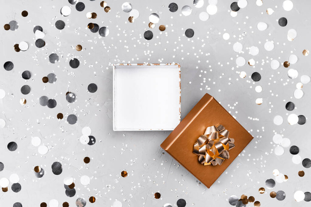 Present box on silver sparkling background. - Foto, afbeelding