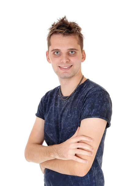 A young handsome man standing in a blue sweater with his arms crossed, smiling, looking into the camera, isolated for white background - Fotografie, Obrázek