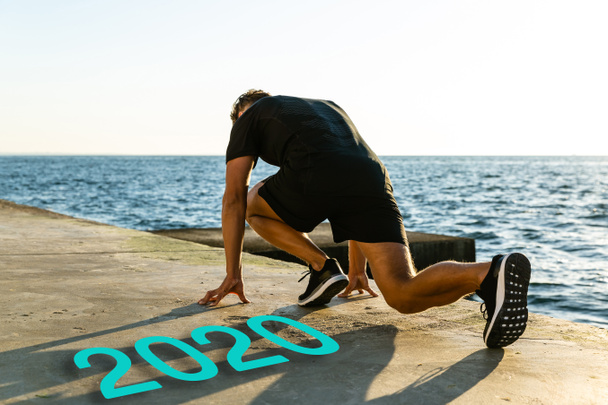 mladý běžec stojící na startovním místě na náspu u písmen roku 2020 - Fotografie, Obrázek