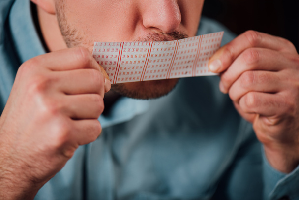 cropped view of man kissing lottery ticket for luck - Photo, Image