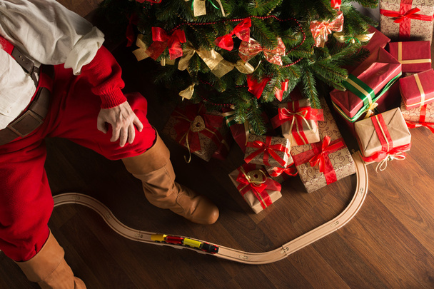 Unrecognizable Santa Claus playing with wooden railroad near Chr - Φωτογραφία, εικόνα