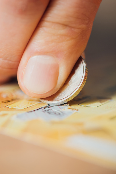 vista de perto da moeda de prata na mão do jogador riscando bilhete de loteria
 - Foto, Imagem