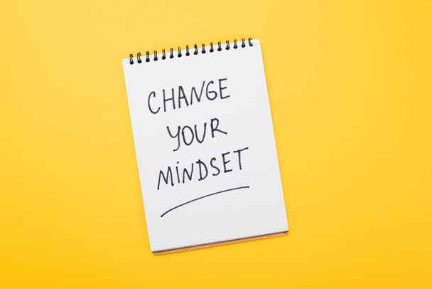 vista superior do notebook com mudança sua inscrição mentalidade na superfície amarela
  - Foto, Imagem