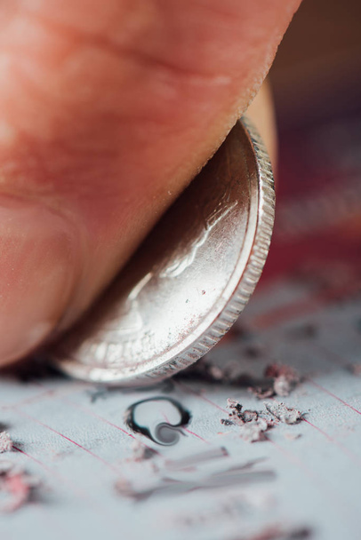 zblízka pohled na stříbrné mince v ruce gambler poškrábání loterijní karty - Fotografie, Obrázek