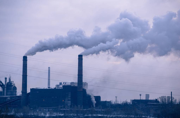 Dos chimeneas de una planta metalúrgica en una mañana nublada
  - Foto, imagen