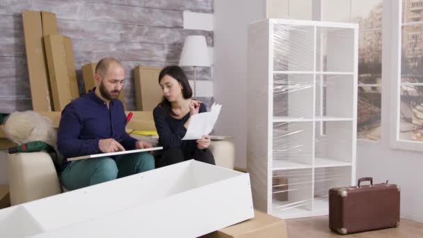 Couple smiling while assembling a shelf as a team - Footage, Video