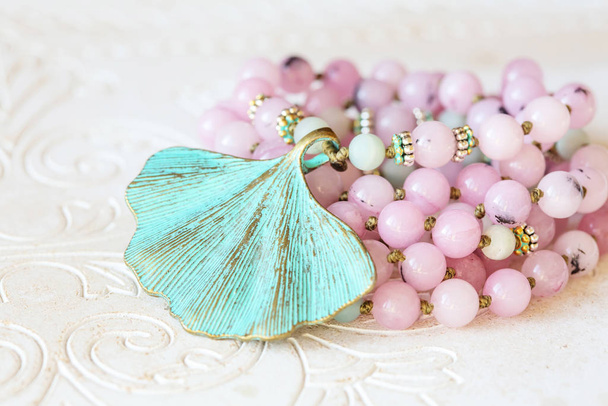 Šperky Mala náhrdelník s přírodními minerálními korálky na bílém dřevěném dekorativním pozadí - Fotografie, Obrázek