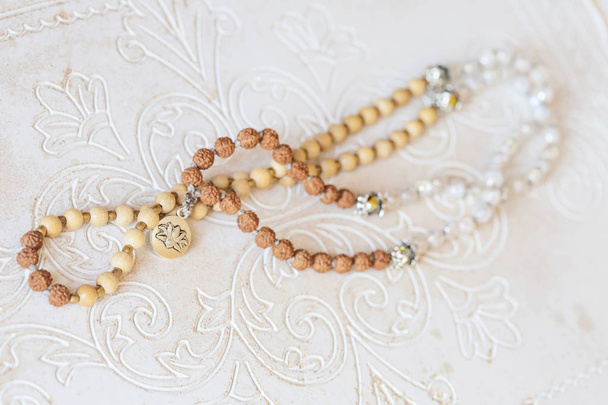 Bijoux collier mala avec perles minérales naturelles sur fond décoratif en bois blanc
 - Photo, image